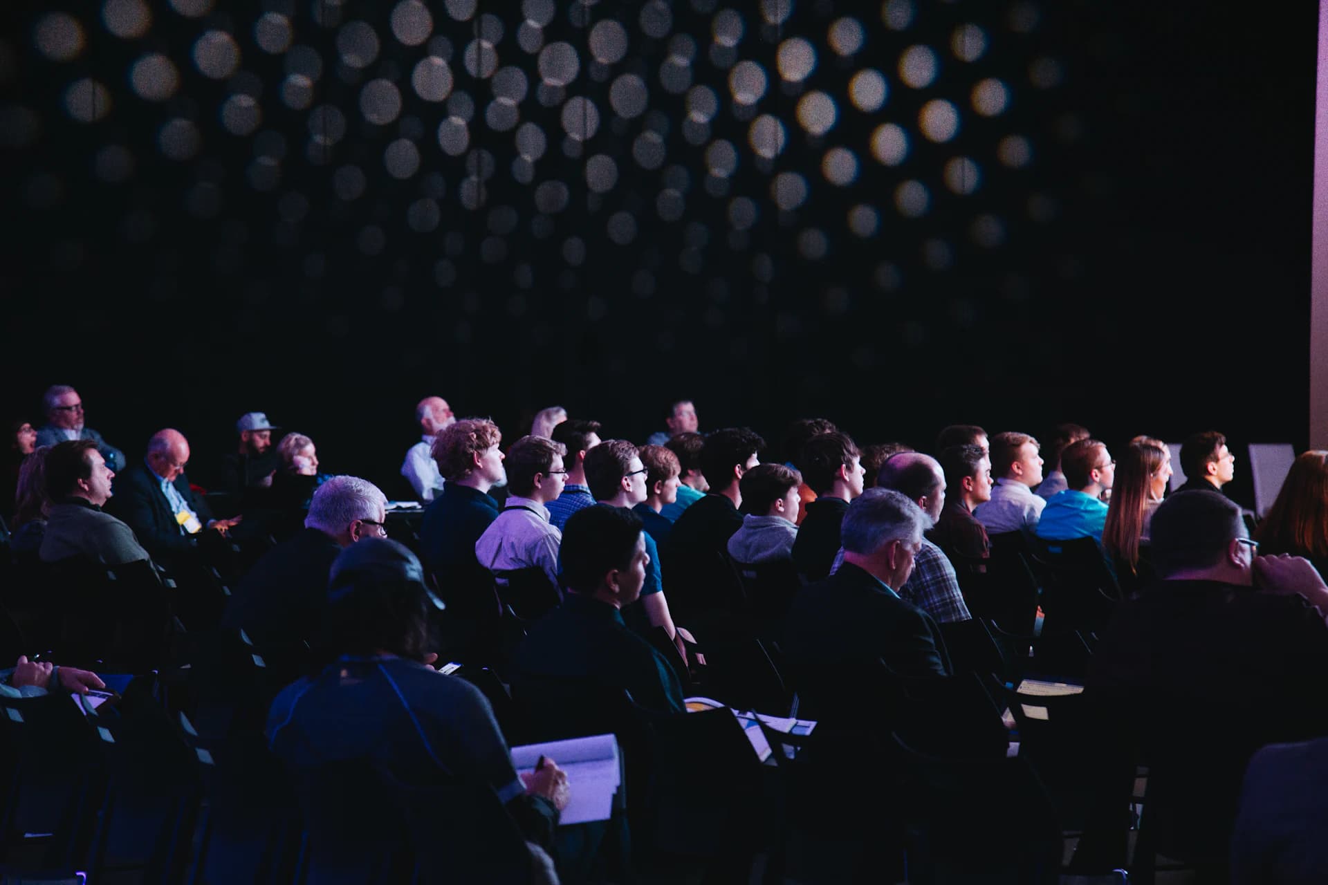 Audience watching a talk in a dark auditorium